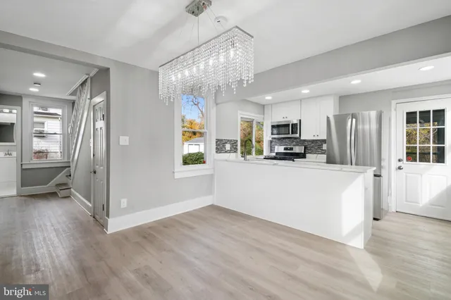 a view of a kitchen with refrigerator and wooden floor