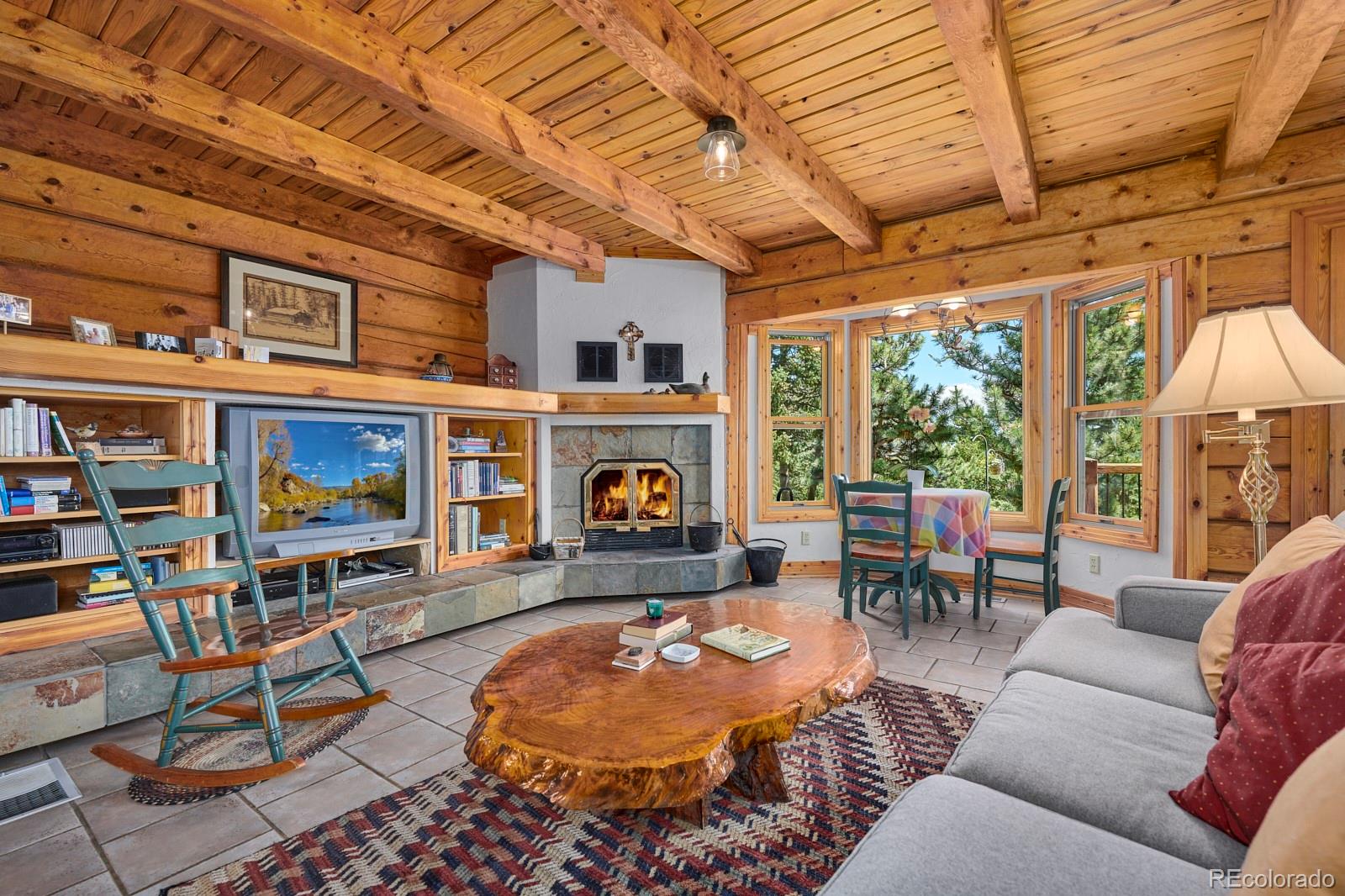 2847 Ridge Road Nederland, CO 80466 - Photo 12 of 40 a living room with furniture a fireplace and a table