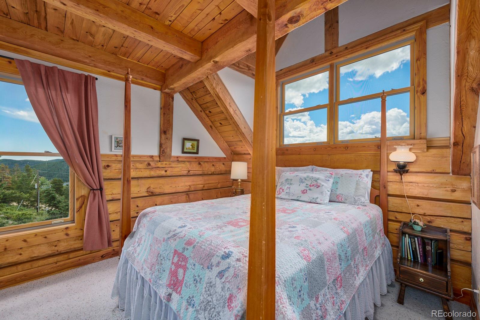 2847 Ridge Road Nederland, CO 80466 - Photo 23 of 40 a bedroom with a bed next to a large window