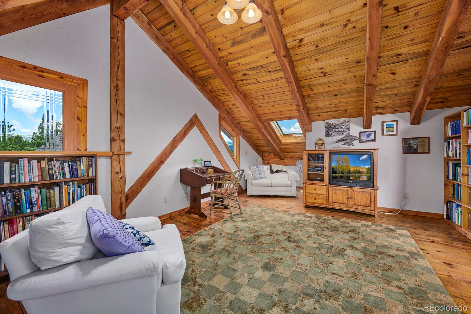 2847 Ridge Road Nederland, CO 80466 - Photo 24 of 40 a living room with lots of furniture and a book shelf