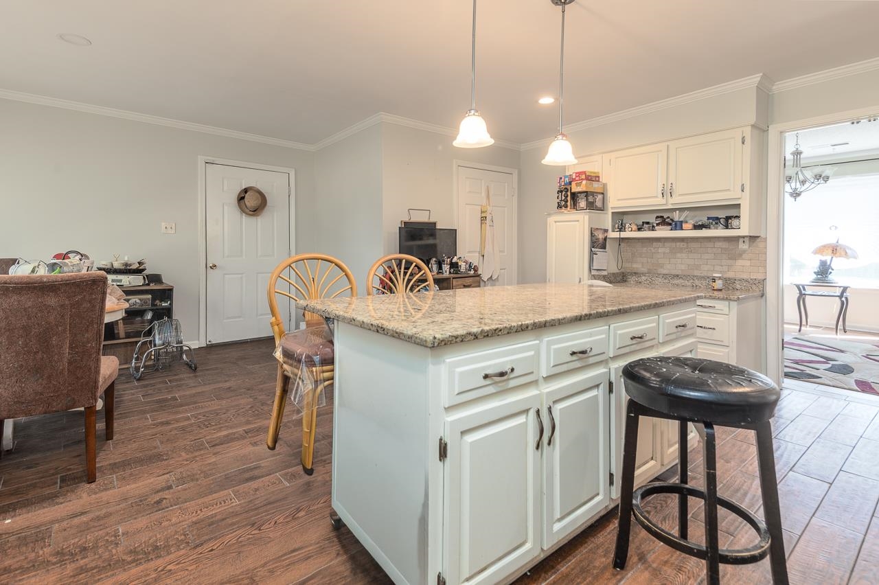 7829 Gateway Inlet Memphis, TN 38119 - Photo 17 of 30 a kitchen with kitchen island a stove a table and chairs in it