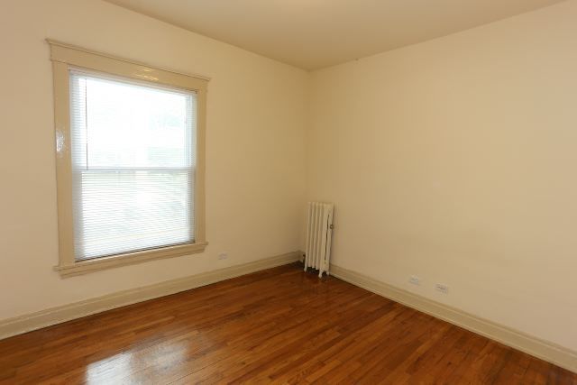 4716 North Racine Avenue, Unit 2E Chicago, IL 60640 - Photo 12 of 19 an empty room with wooden floor and windows