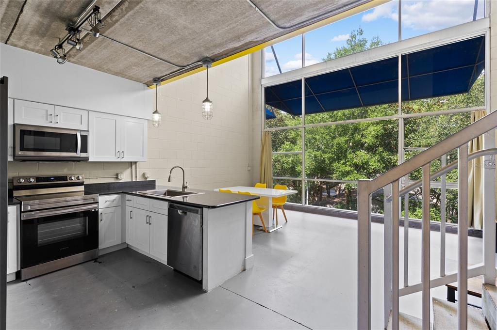 2515 Southwest 35th Place, Unit 203 Gainesville, FL 32608 - Photo 11 of 22 a kitchen with stainless steel appliances granite countertop a stove and a wooden cabinets