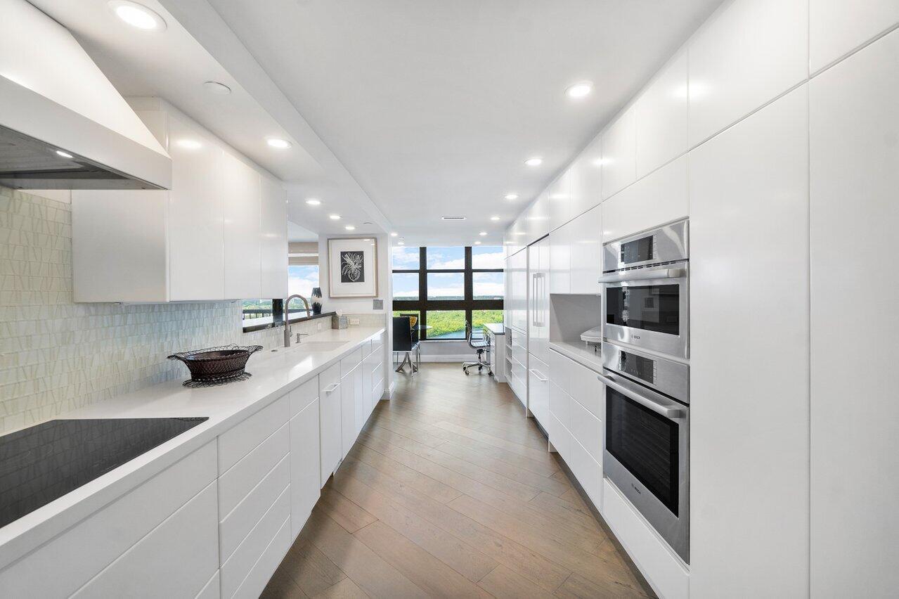 a large kitchen with stainless steel appliances and a large window