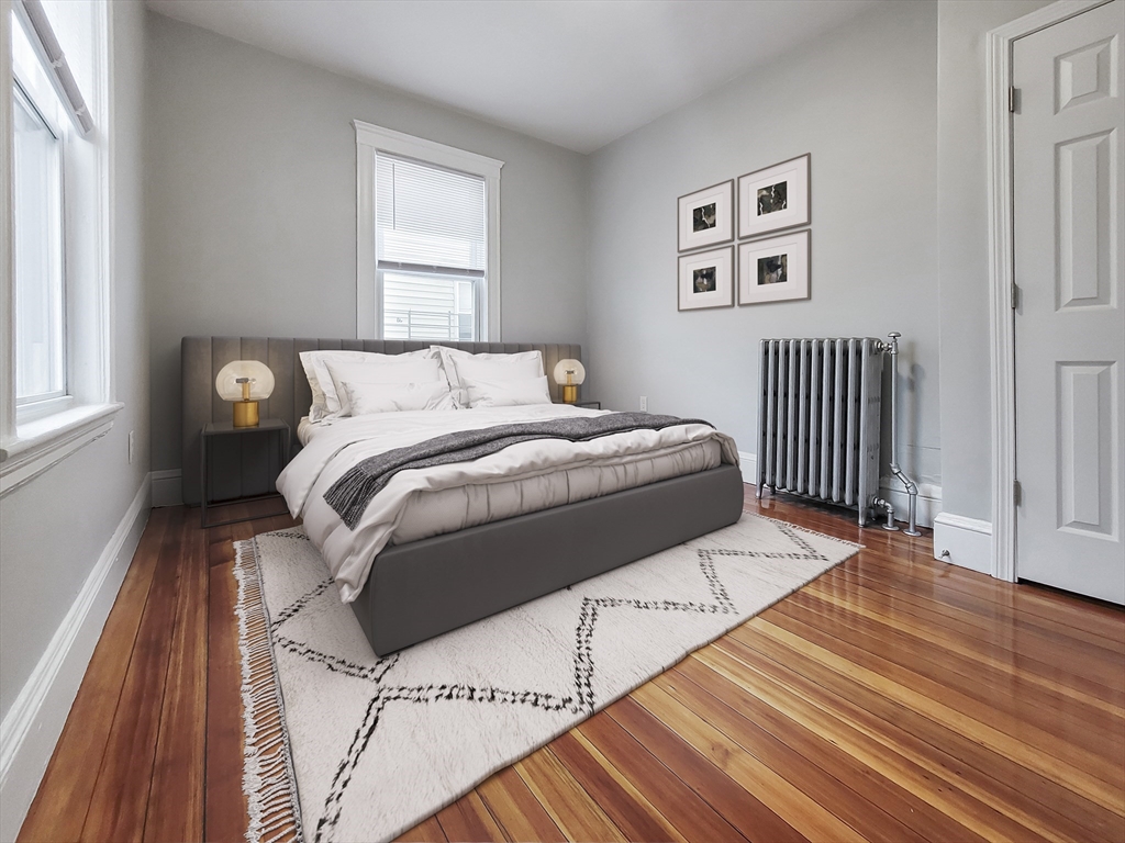 108 Callender Street, Unit 3 Boston, MA 02124 - Photo 3 of 12 a bed sitting in a bedroom next to a window