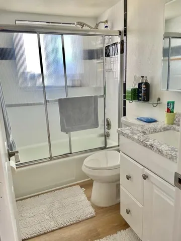 a bathroom with a granite countertop sink toilet and shower