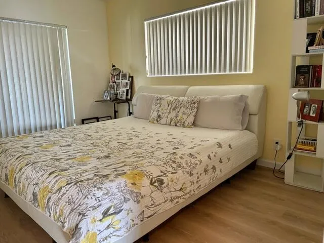 a large bed sitting in a bedroom next to a window