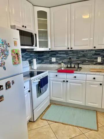 a kitchen with white cabinets and white appliances