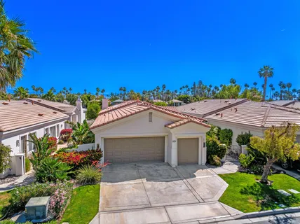 a view of a house with a yard and potted plants
