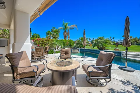 a view of a chairs and table in patio with a fire pit