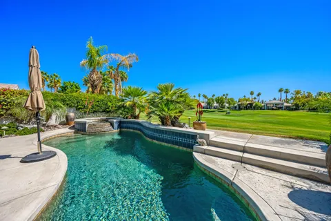 a swimming pool with outdoor seating and yard