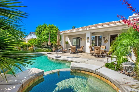a view of a patio with couches table and chairs and potted plants