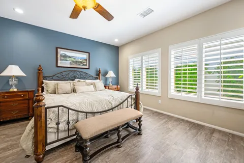 a spacious bedroom with a bed and a dresser next to a window