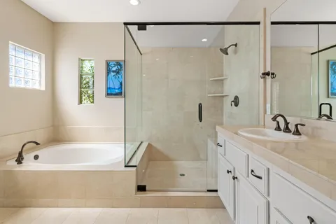 a bathroom with a tub sink and mirror