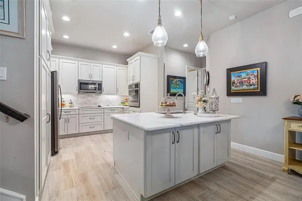 a kitchen with white cabinets and stainless steel appliances