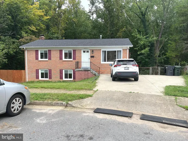a front view of a house with a garden and parking space