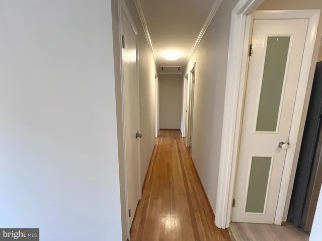 a view of a hallway with wooden floor