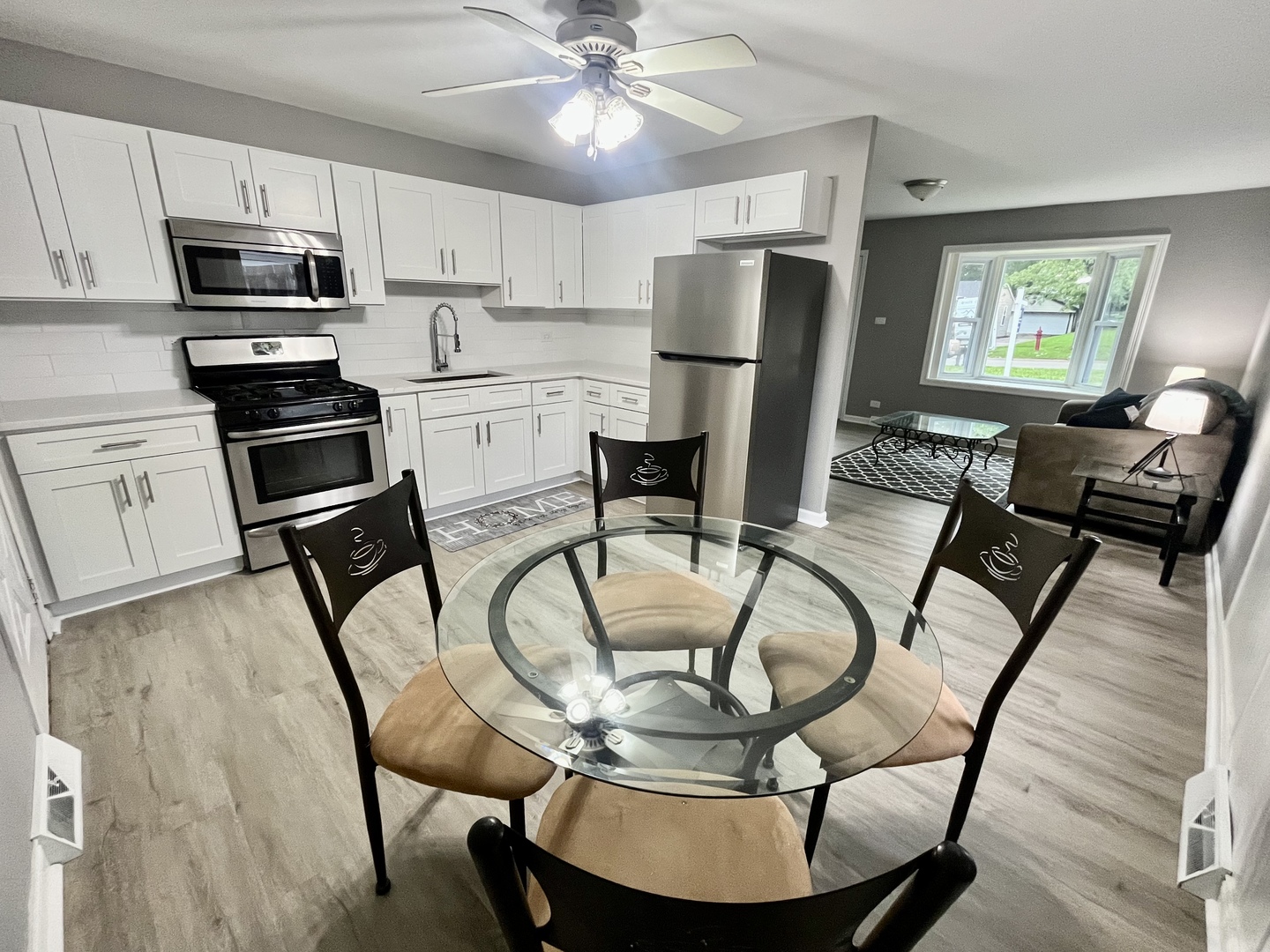 207 MacGregor Road Lockport, IL 60441 - Photo 5 of 14 a kitchen with stainless steel appliances granite countertop a dining table chairs refrigerator and microwave