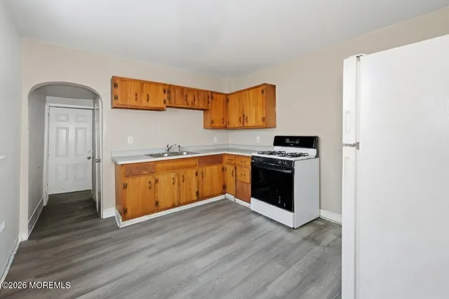 a kitchen with granite countertop a stove and a refrigerator