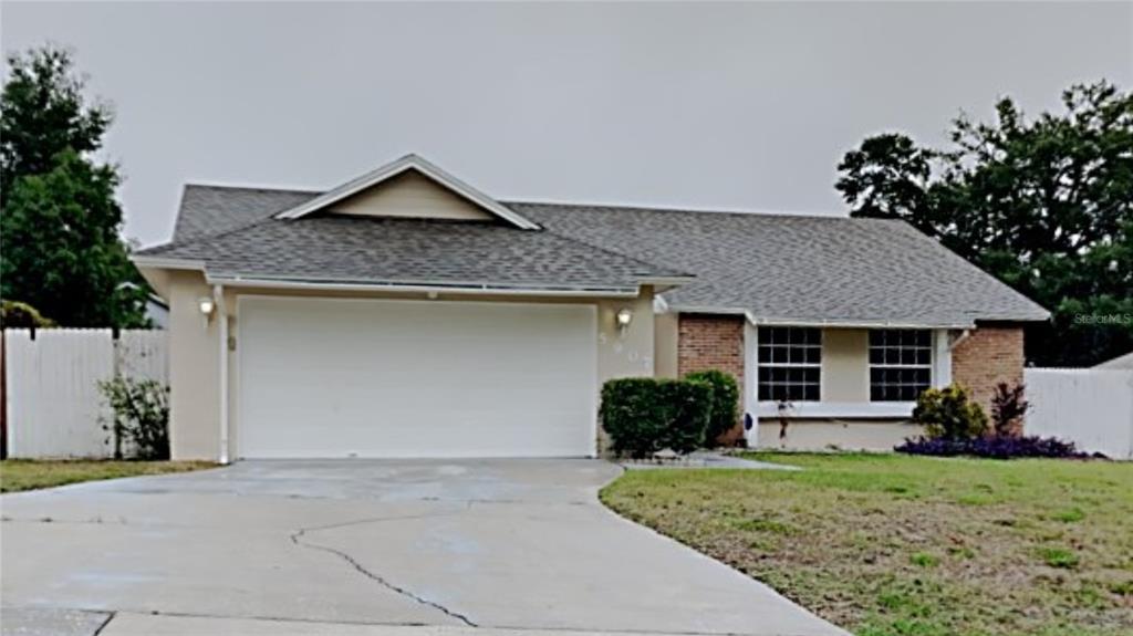 5907 White Egret Lane Orlando, FL 32810 - Photo 1 of 1 a front view of a house with a yard and garage