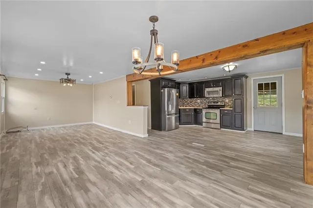 a kitchen with stainless steel appliances wooden floor sink and wooden cabinets