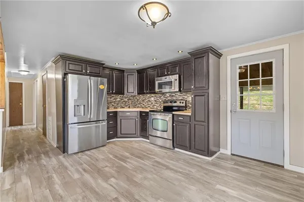 a kitchen with stainless steel appliances granite countertop a refrigerator and a sink