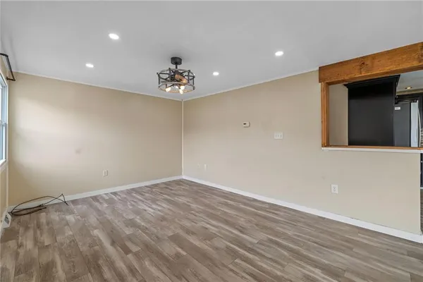 a view of an empty room with wooden floor