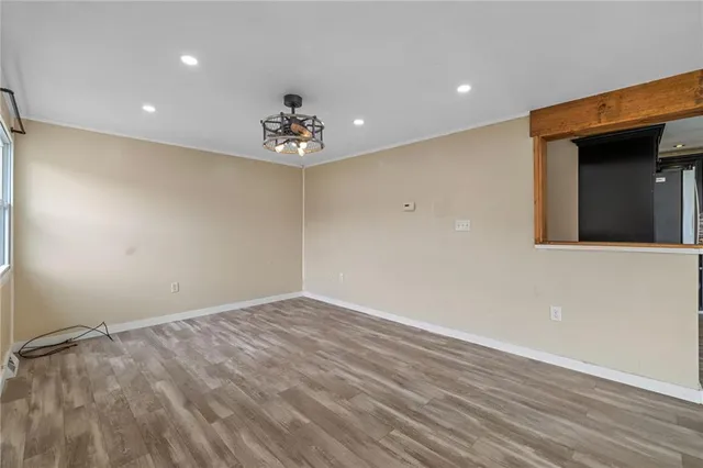 a view of an empty room with wooden floor