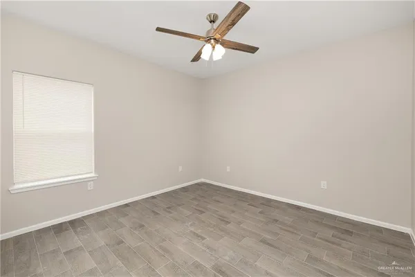 an empty room with a window and a fan