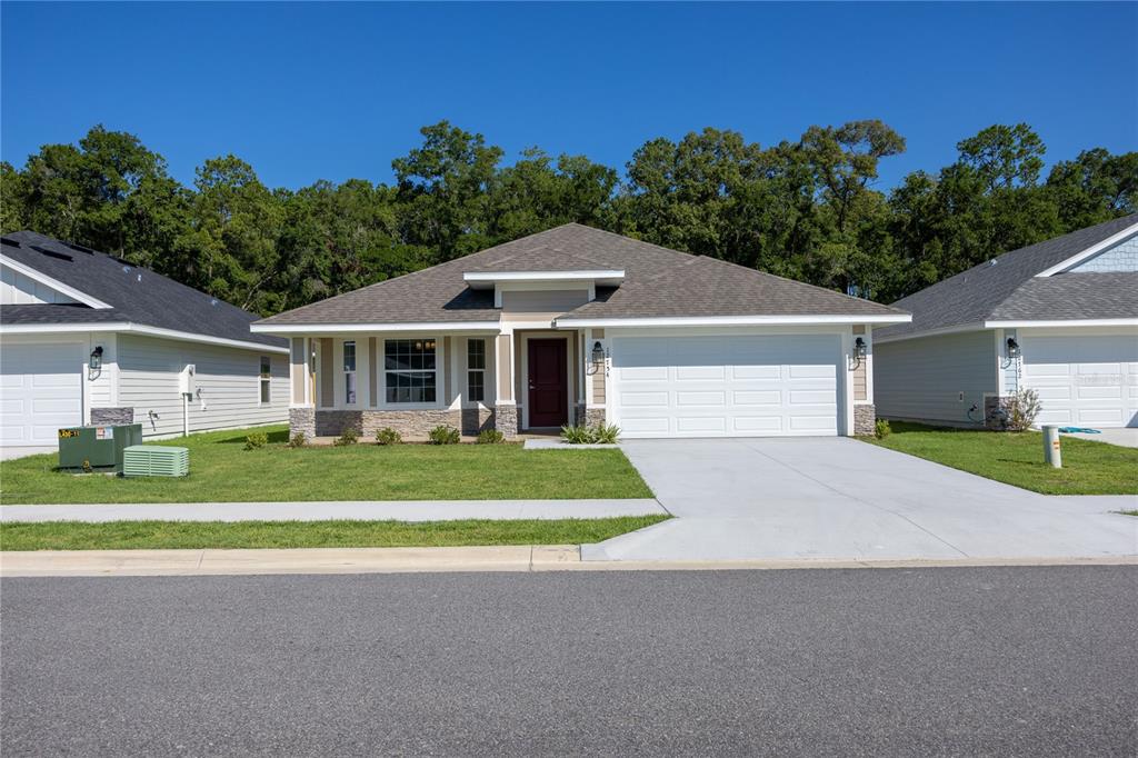 a front view of a house with a yard and trees