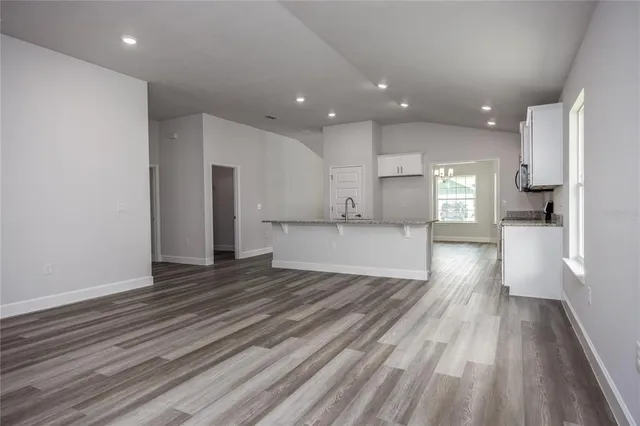a view of a kitchen with wooden floor and a window