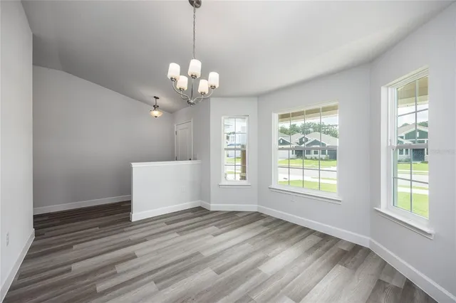 a view of a room with wooden floor and chandelier
