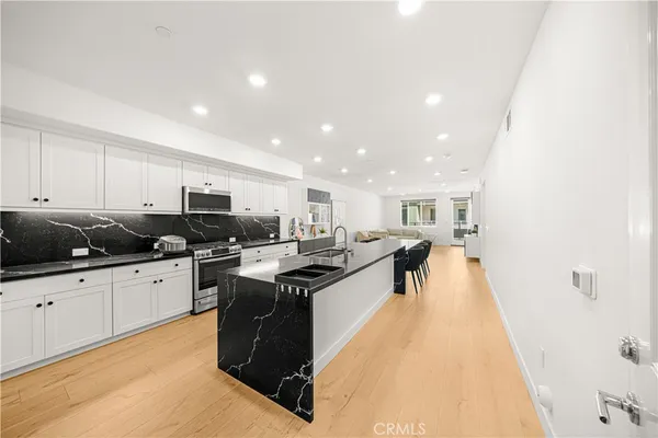 a kitchen with stainless steel appliances kitchen island granite countertop a sink and cabinets