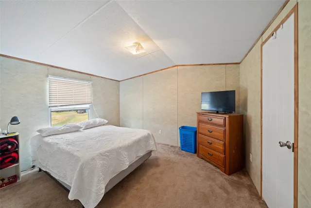 a bedroom with a bed and flat screen tv