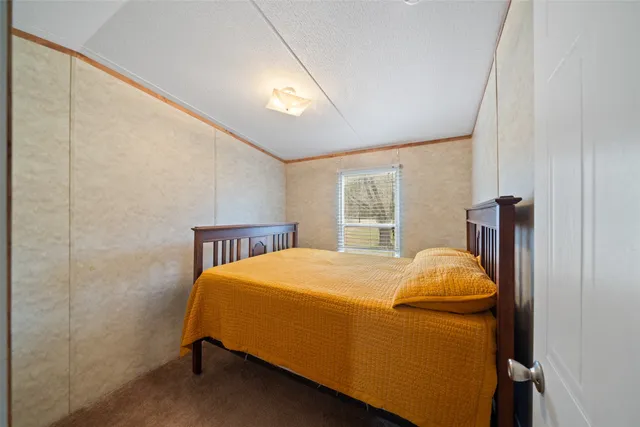 a bed sitting in a bedroom next to a window