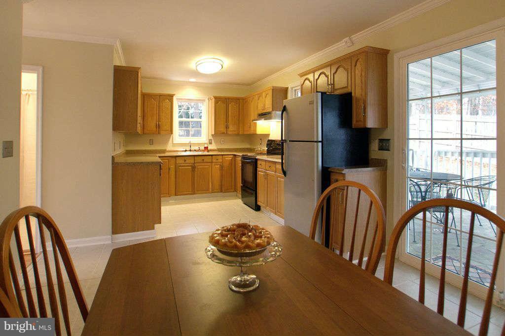 1010 Bernoudy Road White Hall, MD 21161 - Photo 10 of 28 a kitchen with stainless steel appliances granite countertop a stove a refrigerator a stove a dining table and chairs with wooden floor