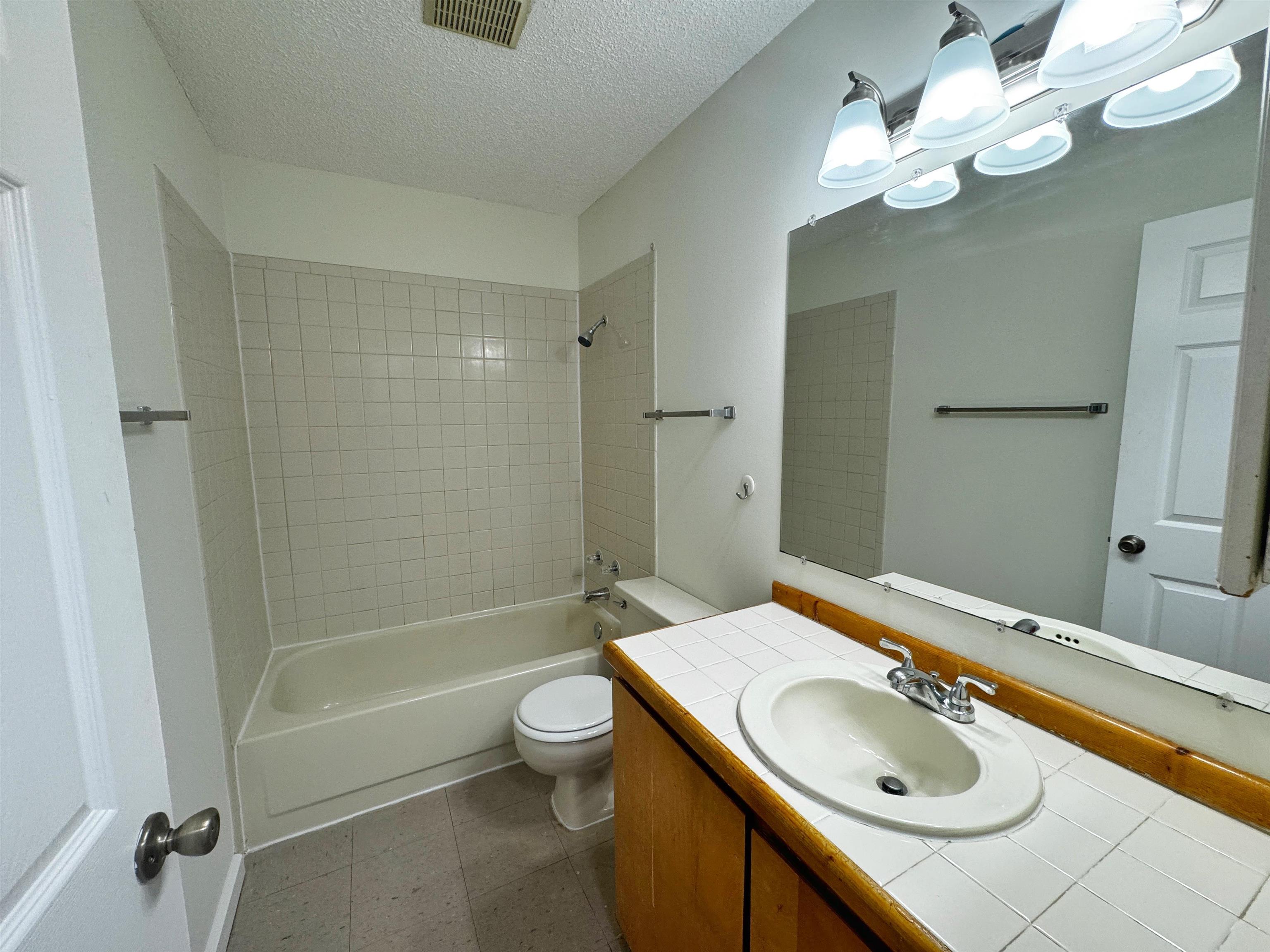 204 8th Street, Unit A St. Augustine, FL 32080 - Photo 10 of 15 a bathroom with a sink a toilet and shower