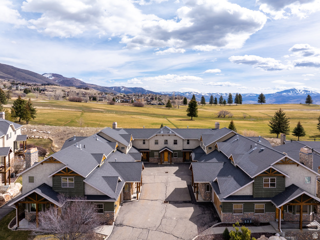 Multi-unit property featuring complementary architecture with stone accents, covered entryways, and dark shingle roofing