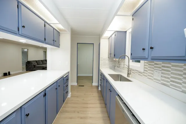 a large kitchen with a sink and cabinets