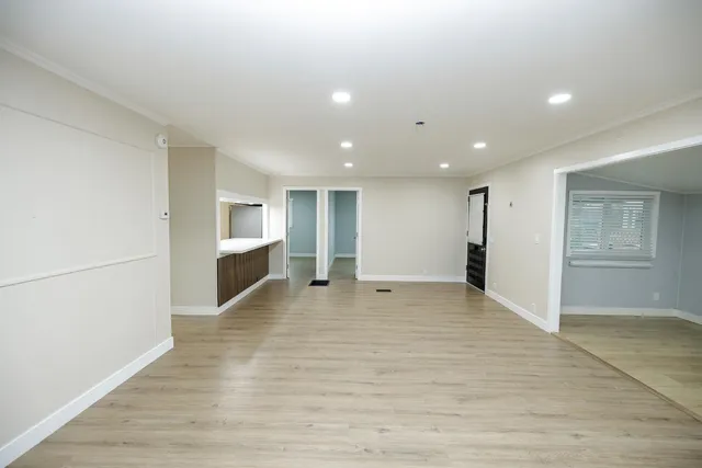 a view of an empty room with closet and entryway