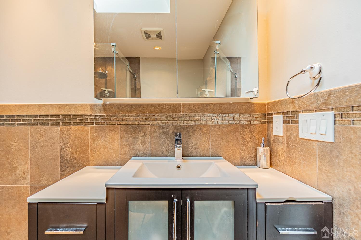 4603 Stonehedge Road Edison, NJ 08820 - Photo 24 of 35 a bathroom with a sink and a mirror