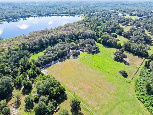 an aerial view of residential houses with outdoor space and lake view