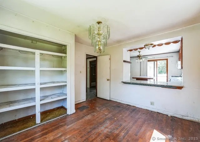 a view of a hallway with wooden floor and chandelier