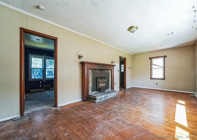 an empty room with windows and a fireplace