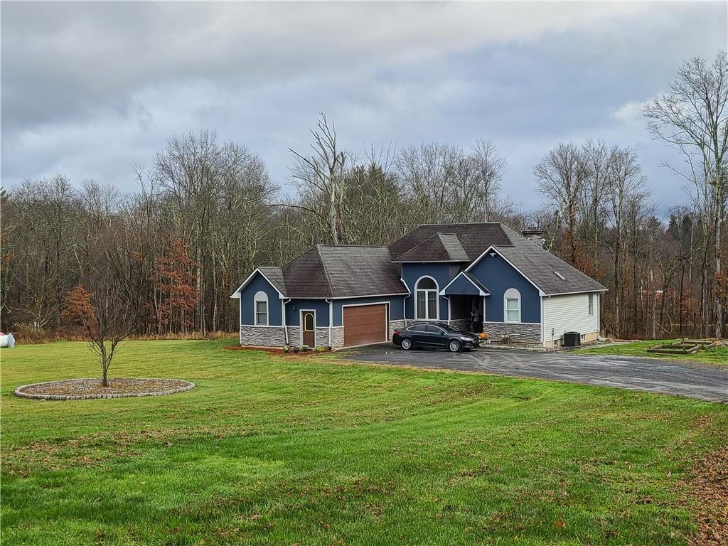 a front view of a house with a yard and trees