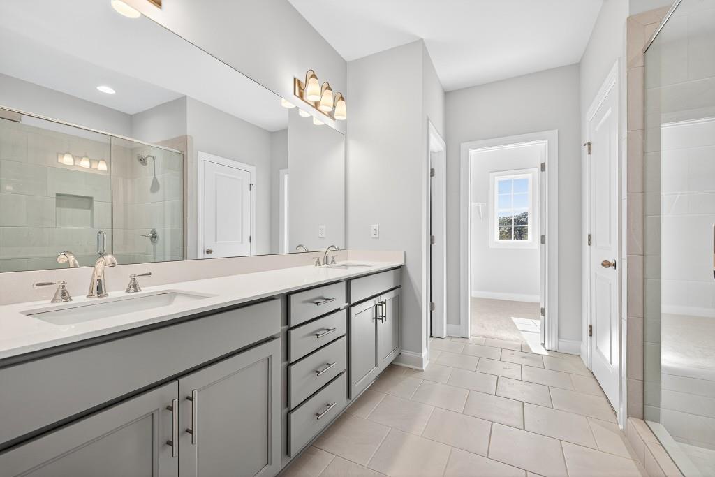 5566 Spring Street Flowery Branch, GA 30542 - Photo 35 of 66 a spacious bathroom with a granite countertop double vanity sink mirror and