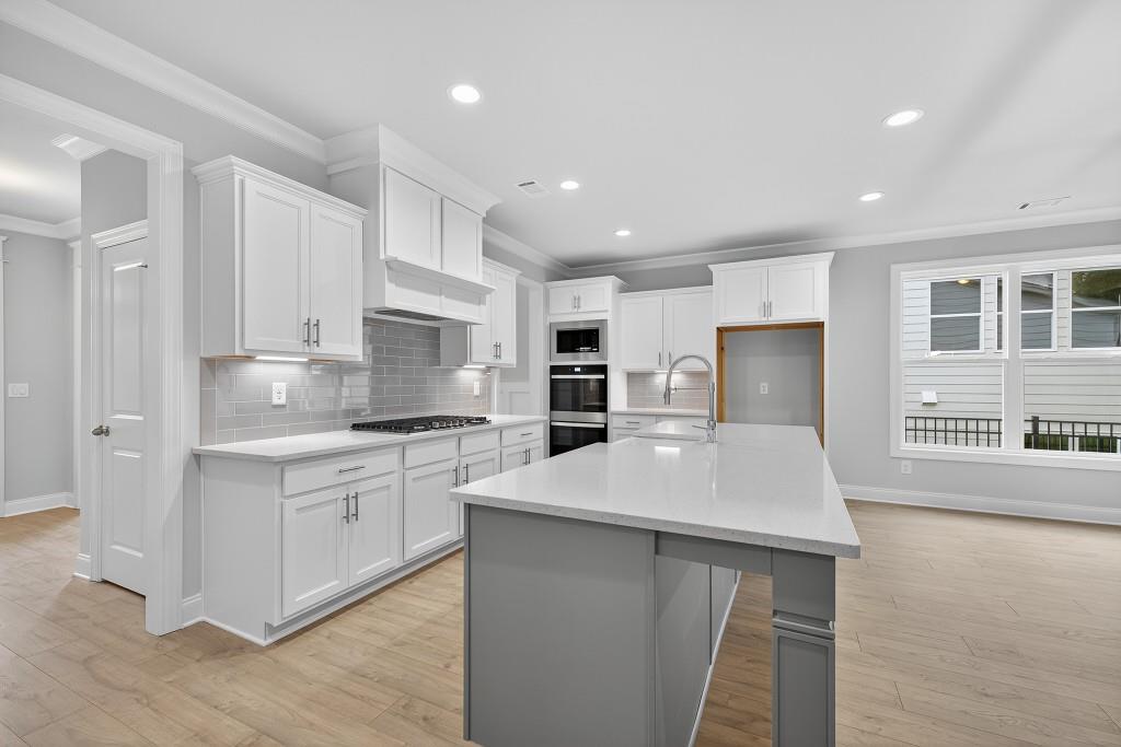 5566 Spring Street Flowery Branch, GA 30542 - Photo 7 of 66 a kitchen with stainless steel appliances a refrigerator sink stove microwave and cabinets