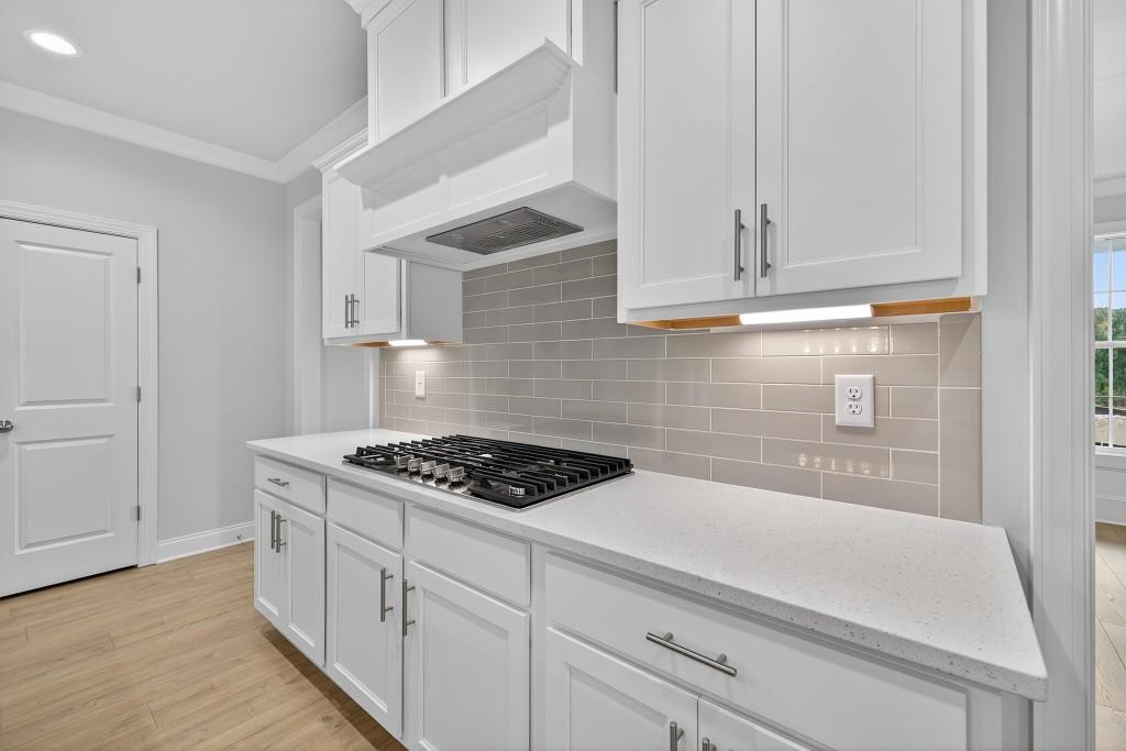 5566 Spring Street Flowery Branch, GA 30542 - Photo 10 of 66 a kitchen with white cabinets and a stove