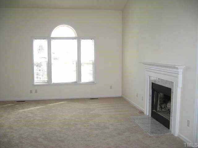 Great living room with cathedral ceiling, ceiling fan, & marble-surround fireplace