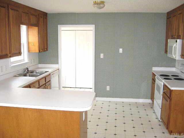 Spacious kitchen with custom cabinets & white appliances